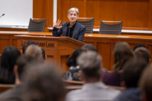 Photo of a person speaking to an audience from a lecturn