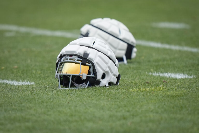 Football players clap their hands after a play.