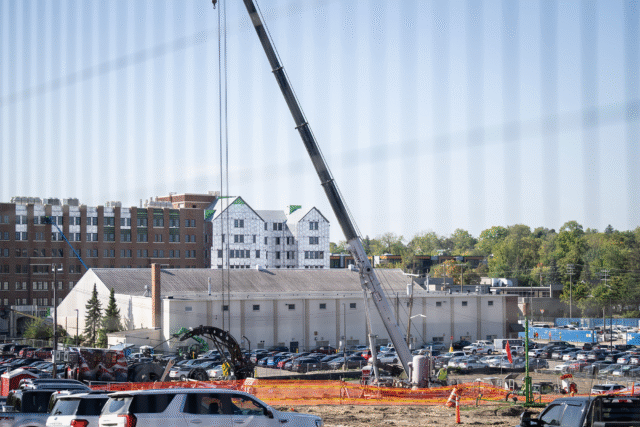 A large drilling crane surrounded by vehicles and fencing