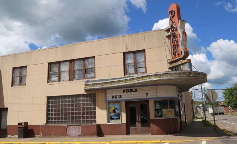 Black-and-white photo of the Park Theater, with a marquee displaying “John Hodiak Ambush” and a movie poster visible near the entrance.
