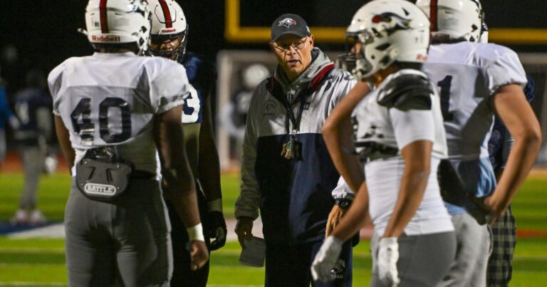 Lackawanna College Coach Mark Duda and lineman Michael Odeyemi watch players during practice on Wednesday.