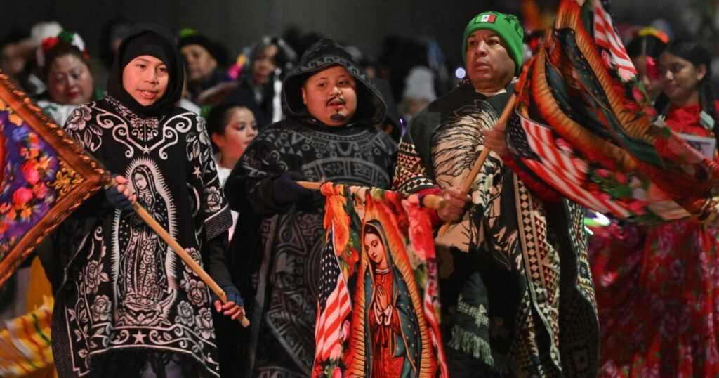 A woman carries her statue of Our Lady of Guadalupe along Friday's procession to St. Nicholas Church in Wilkes-Barre to be blessed.