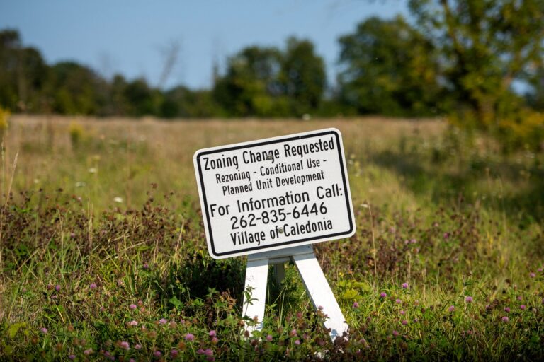 Workers use cranes and other machinery to place metal beams during construction.