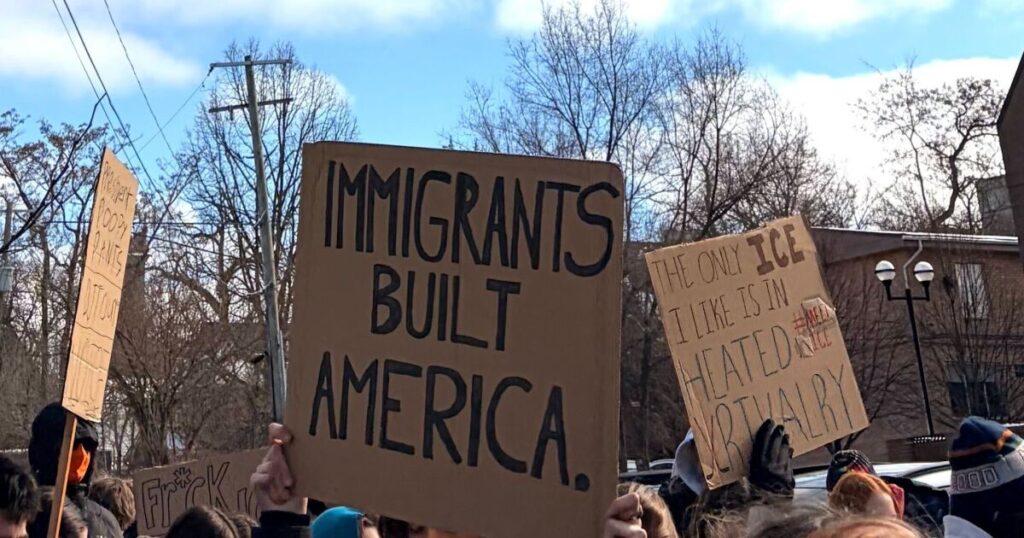 Students hold signs reading "ICE is the KK" and "Anyone who is depriving you of freedom isn't deserving of a peaceful approach - Malcom X"