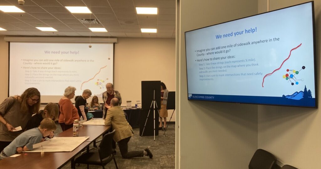 Buncombe County residents speak with staff and volunteers during a community meeting Monday, March 9, 2026.