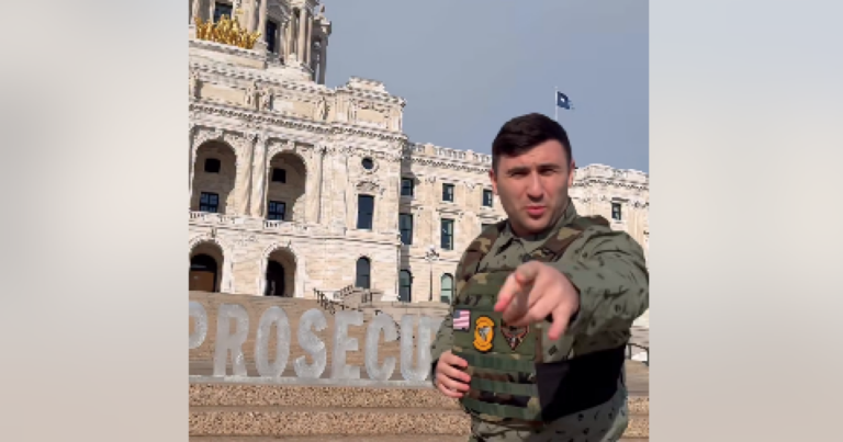 Jake Lang knocks over letters in an ice sculpture outside the Minnesota state Capitol on Feb. 5, 2026. The sculpture said Prosecute ICE. Lang turned it into Pro Ice.