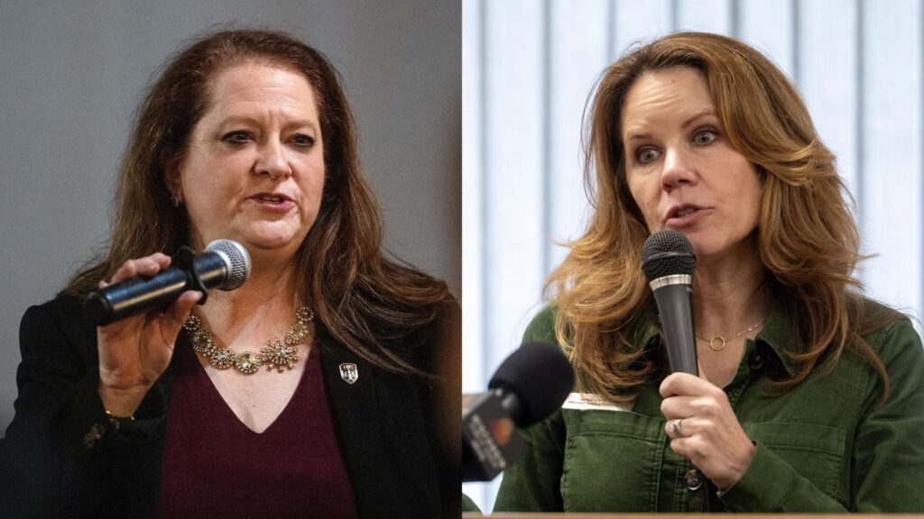 Two women speaking into microphones; the woman on the left wears a dark blazer and maroon top, while the woman on the right wears a green shirt and stands in front of a window.