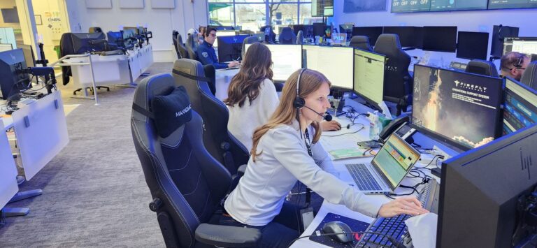 A lunar lander stands on the surface of the Moon with Earth visible in the background and the Sun rising over the horizon.