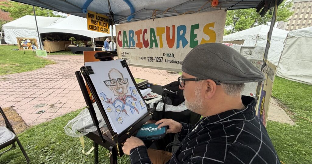 John Krupa begins drawing a caricature of WVIA Chief Engineer Mark Ruddy at the 2026 Fine Arts Fiesta.