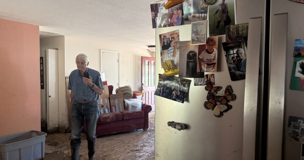 Alan Gubanich shows photos he took shortly after the flashflood on June 19, 2026, including this one of his art supplies coated in mud in the sun room.
