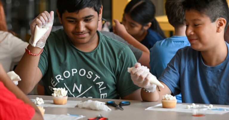 Alondra Llangari, Kiara Llangari and Jimena Quizhpi finish decorating their cupcakes with food dye.