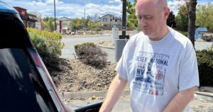 Electric Road Trip Navigating Nevadas Sparse EV Charging Network - Common Good News Scott Allison, standing next to his Kia EV9, stops at an overlook along Geiger Grade on the way from Reno to Virginia City.