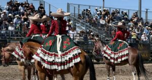 One of the riders and her horse whips by the edge of the rodeo arena.