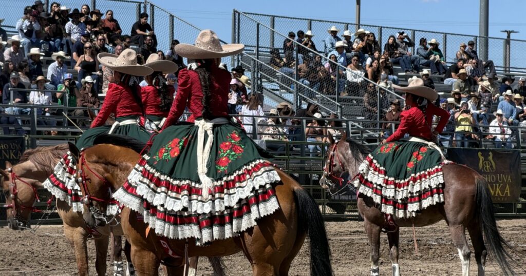One of the riders and her horse whips by the edge of the rodeo arena.