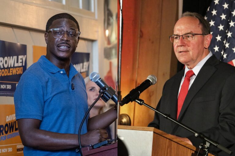 Two men stand at podiums, each speaking at separate political events; campaign signs and an American flag are visible in the background.