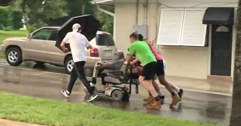 Four Young Heroes Help Elderly Woman in Rain with Scooter - Common Good News men push elderly woman