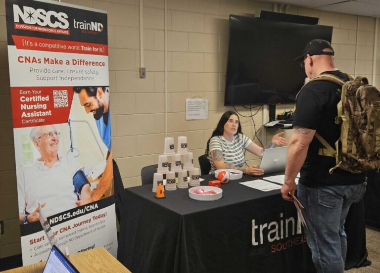 Job Market Faces Challenges July Sees 23000 Jobs Lost in - Common Good News McKenna Melby of the North Dakota State College of Science speaks with a job fair attendee in Fargo, North Dakota, on July 28, 2026. Melby was recruiting potential students for the certified nursing assistant program.(Photo by Jeff Beach/North Dakota Monitor)