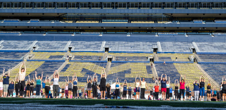 U-M employees doing yoga on the field in Michigan Stadium