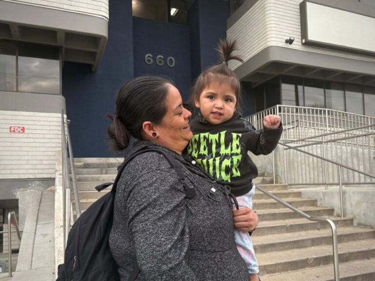 A mother and daughter are pictured at a protest against arrests of immigrants at green card appointments in Salt Lake City. Two lawsuits filed Monday challenge new federal guidance that could affect green card applicants who have used Medicaid or food assistance. (Photo by Annie Knox, Utah News Dispatch)